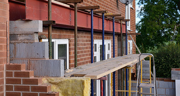 the back of a brick house under an extension project to extend it outwards