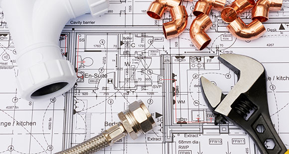 blueprints of a plumbing system with different plumbing components and a wrench on top of it