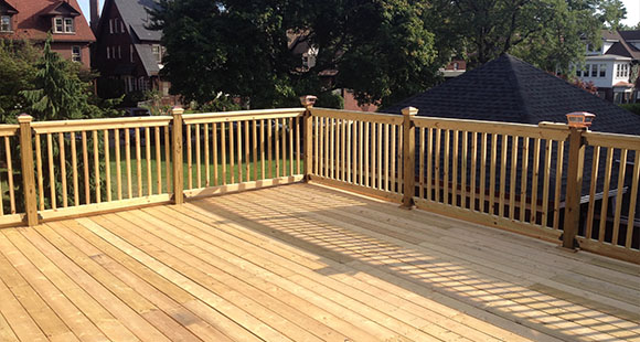 a wooden decking with fences build on a back garden