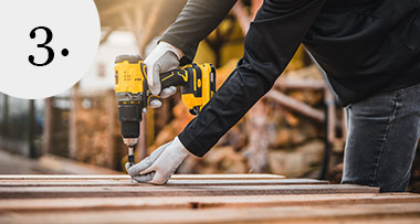 a person using an electric drill to drill a screw into a plank of wood